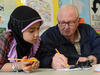 Burmese Muslim girl receiving assistance with her homework