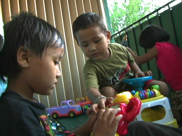 Children from Burma playing on apartment balcony