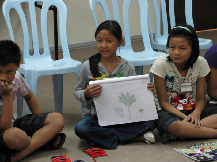 Girl explaining her drawing during youth CO class