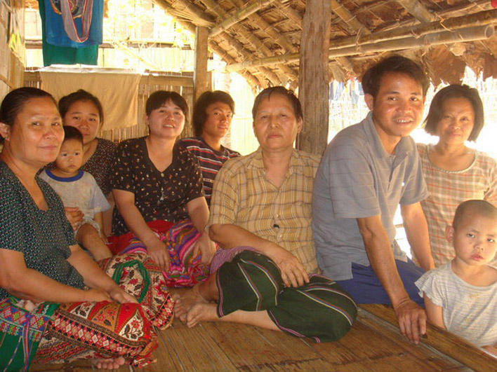 Refugees sitting on front porch in Mae La Camp